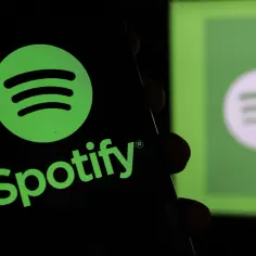 Logo Spotify na czarnym tle, z rozmytym logo na zielonym tle w tle.